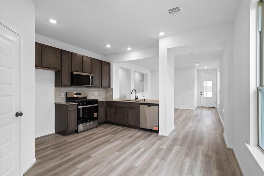 Create lasting memories with family and friends in this inviting kitchen/dining room! It showcases high ceilings, recessed lighting, custom paint, large window, and an access door to the backyard.