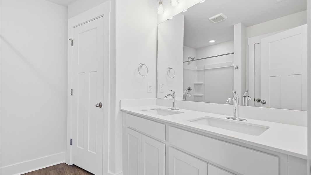 Notable primary suite with dual vanities and walk-in shower in this prime Greenville villa Notable primary suite with dual vanities and walk-in shower in this prime Greenville villa