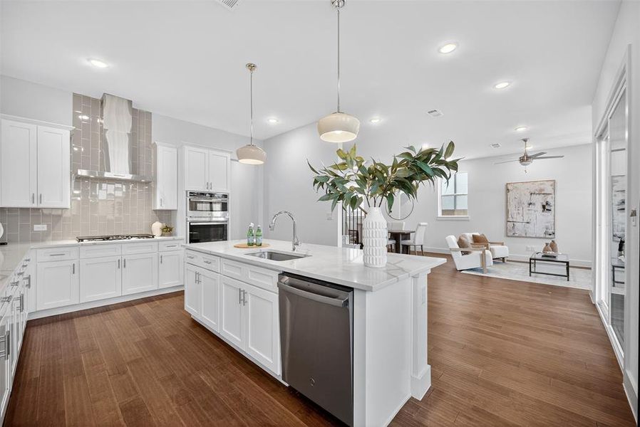 Kitchen featuring tasteful backsplash, white cabinetry, appliances with stainless steel finishes, ceiling fan, and open floor plan
