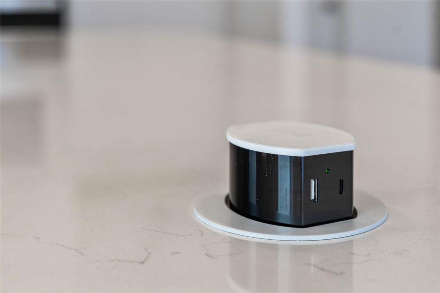 The added pop-up electrical outlet fixture sits nearly flush with the countertop when not in use, preserving a clean, uncluttered aesthetic. A simple press on the top causes the unit to rise up, providing access to power. The added pop-up electrical outlet fixture sits nearly flush with the countertop when not in use, preserving a clean, uncluttered aesthetic. A simple press on the top causes the unit to rise up, providing access to power.