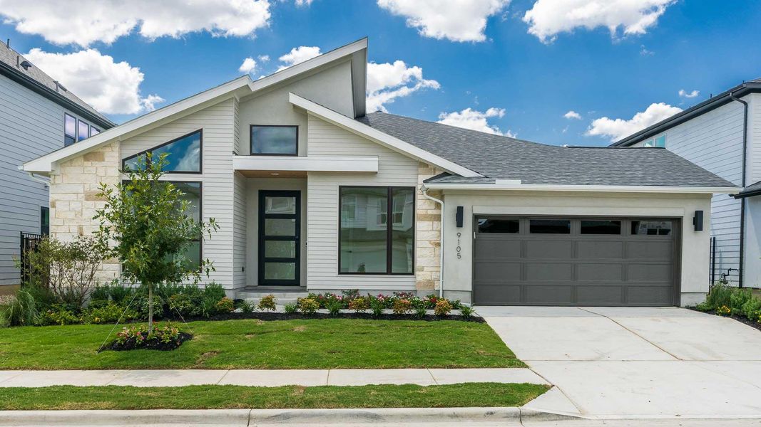 Contemporary home featuring stone siding, a shingled roof, an attached garage, concrete driveway, and a front lawn Contemporary home featuring stone siding, a shingled roof, an attached garage, concrete driveway, and a front lawn