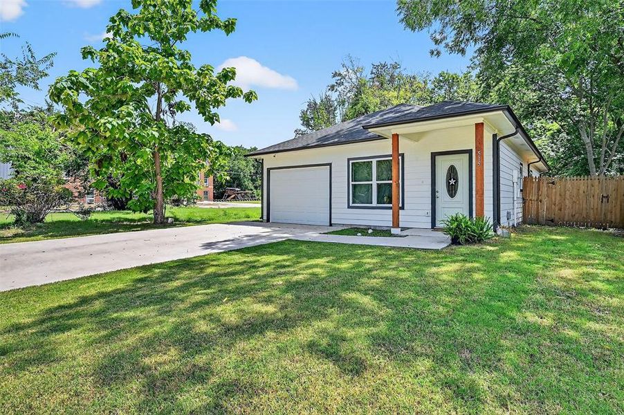 View of front facade featuring driveway and a garage View of front facade featuring driveway and a garage