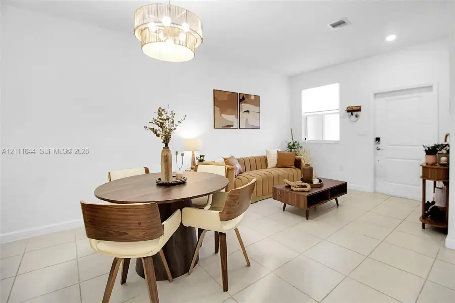 Neutral ceramic tile flooring, multi-tiered drum pendant lighting, and a single-panel interior door Neutral ceramic tile flooring, multi-tiered drum pendant lighting, and a single-panel interior door