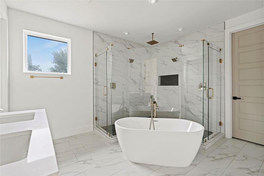 Full bath with marble finish flooring, a freestanding bath, a marble finish shower, double vanity, and recessed lighting Full bath with marble finish flooring, a freestanding bath, a marble finish shower, double vanity, and recessed lighting