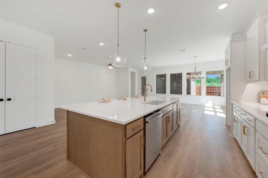 Expansive kitchen island featuring a white countertop, undermount sink, and integrated dishwasher Expansive kitchen island featuring a white countertop, undermount sink, and integrated dishwasher