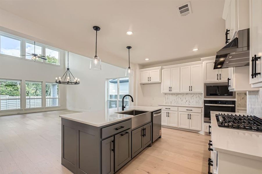 Kitchen with stainless steel appliances, a sink, ventilation hood, plenty of natural light, and recessed lighting Kitchen with stainless steel appliances, a sink, ventilation hood, plenty of natural light, and recessed lighting