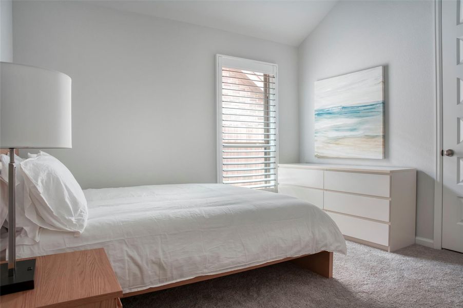 This bedroom is bright and airy, featuring a large window with blinds, a cozy bed with white linens, a modern dresser, and a calming ocean-themed artwork. The neutral color palette creates a serene atmosphere. This bedroom is bright and airy, featuring a large window with blinds, a cozy bed with white linens, a modern dresser, and a calming ocean-themed artwork. The neutral color palette creates a serene atmosphere.