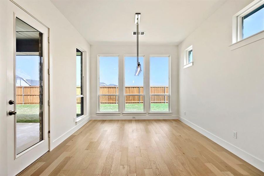 Unfurnished dining area featuring light wood-style floors and baseboards