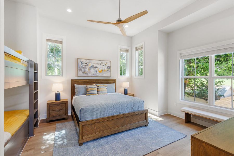 Bedroom 2 featuring multiple windows, light wood-style flooring, recessed lighting, and ceiling fan. Bedroom 2 featuring multiple windows, light wood-style flooring, recessed lighting, and ceiling fan.
