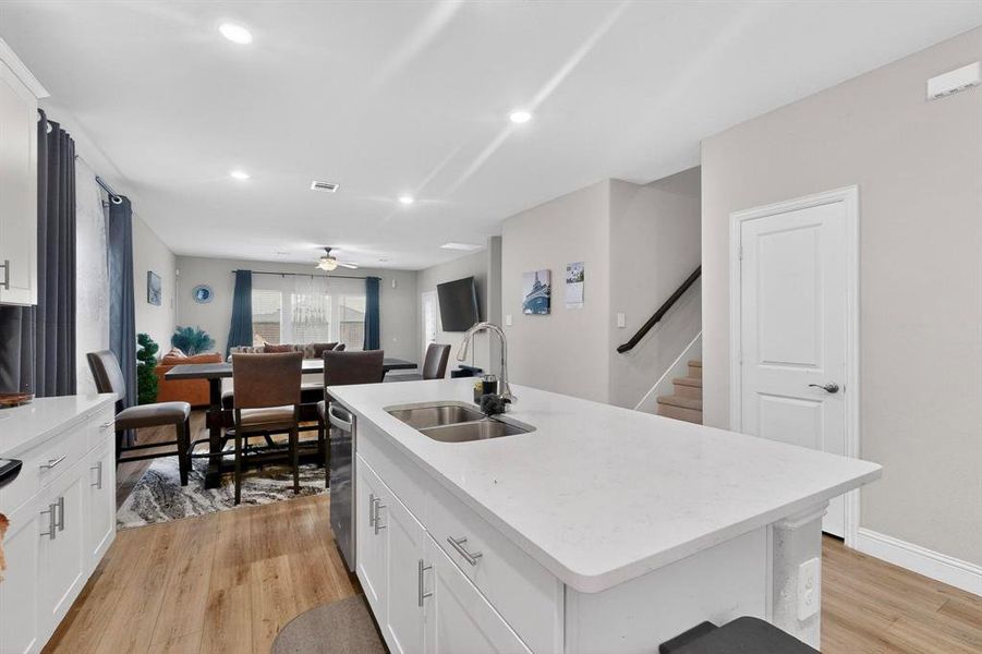 Kitchen featuring white cabinetry, a kitchen island with sink, a ceiling fan, and recessed lighting Kitchen featuring white cabinetry, a kitchen island with sink, a ceiling fan, and recessed lighting