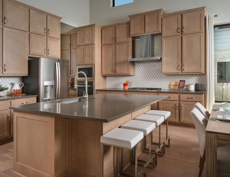 Kitchen with dark countertops, appliances with stainless steel finishes, wood finished floors, and backsplash
