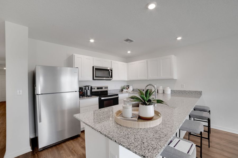 A kitchen with white cabinets.