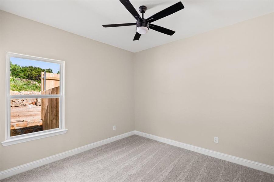 Bedroom with neutral wall paint and light-colored carpet flooring