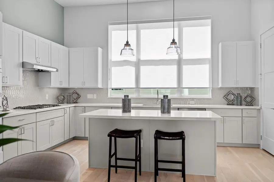 Sleek contemporary cabinetry and a central prep island anchor this light-filled culinary space. Sleek contemporary cabinetry and a central prep island anchor this light-filled culinary space.