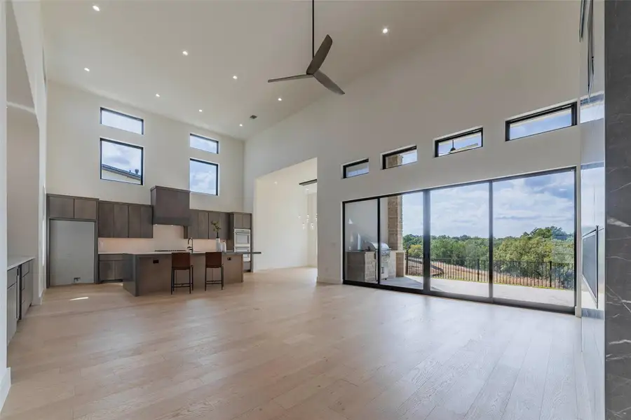 Living area with light wood-style floors, recessed lighting, a high ceiling, and ceiling fan