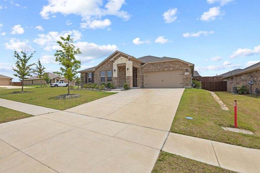Brick exterior with stone accents, a two-car garage, and a concrete driveway Brick exterior with stone accents, a two-car garage, and a concrete driveway