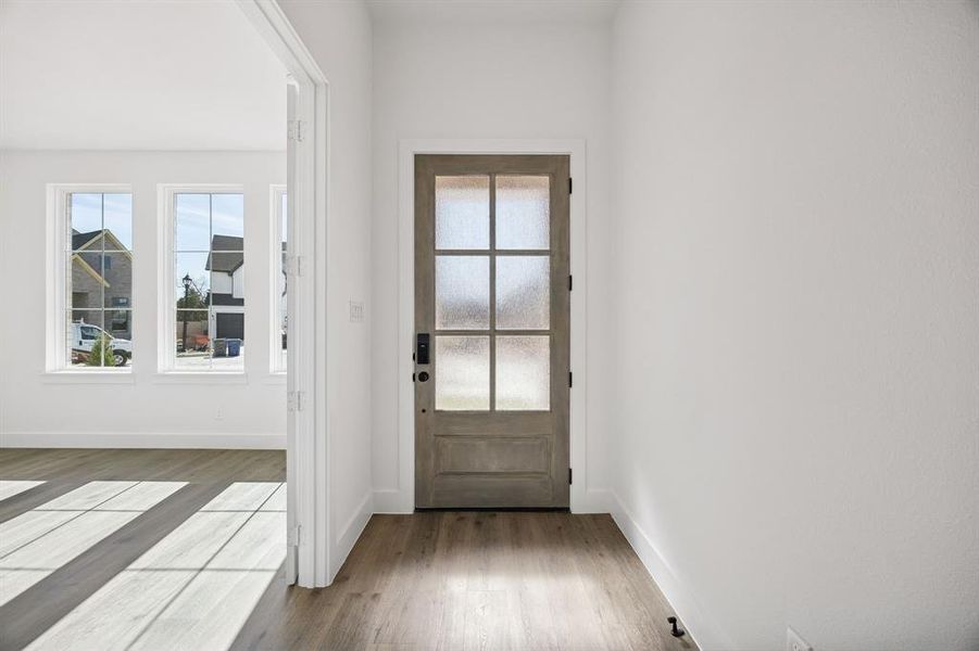 Featuring a beautiful wood and glass door and wide hallway, this entry area is the perfect place to greet family and friends.