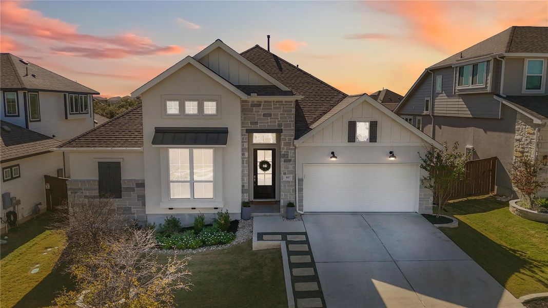 View of front of property featuring board and batten siding, stone siding, concrete driveway, roof with shingles, and a yard View of front of property featuring board and batten siding, stone siding, concrete driveway, roof with shingles, and a yard