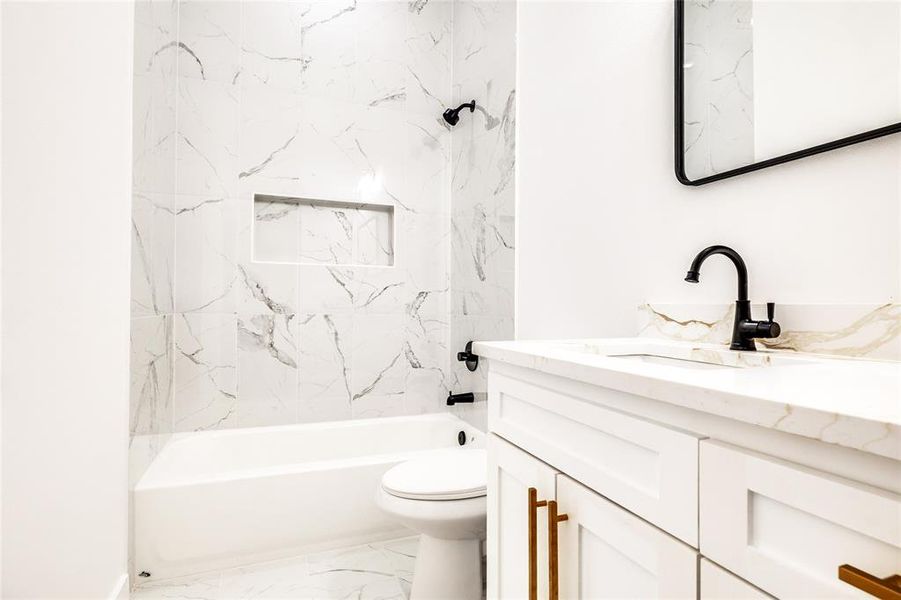 Full bathroom featuring vanity,  shower combination, and light marble finish floors