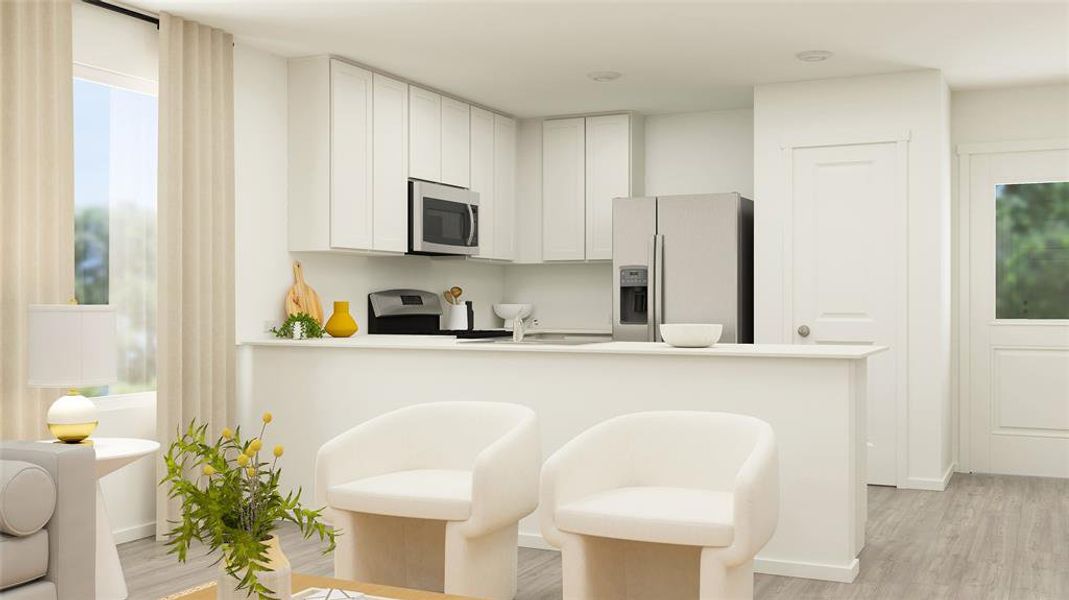 Kitchen featuring kitchen peninsula, stainless steel appliances, light hardwood / wood-style flooring, white cabinetry, and a breakfast bar area