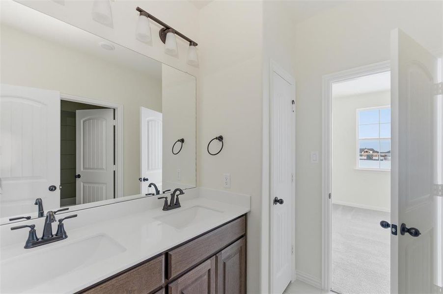 Full bath with double vanity and light carpet