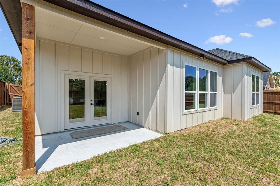 Back of property with french doors, a patio area, and a yard