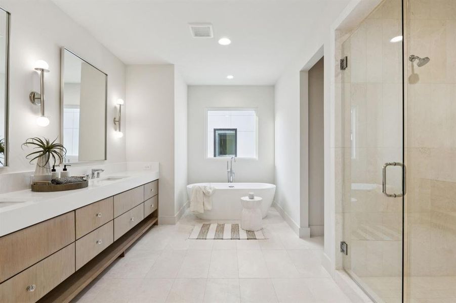 Full bath featuring a shower stall, vanity, a freestanding bath, tile patterned flooring, and recessed lighting