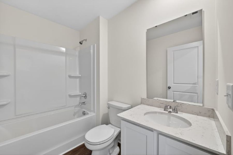 A bathroom with a tub sink and toilet.