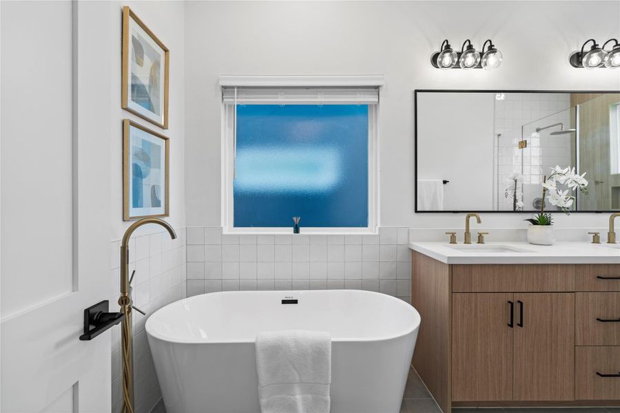 A standalone tub paired with a freestanding faucet creates a stunning piece in the ensuite, inviting you to soak away the day in complete luxury and tranquility.