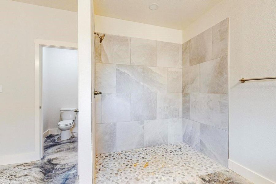 Bathroom with toilet and a tile shower