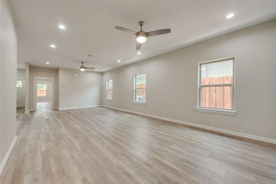 Empty room with ceiling fan and light hardwood / wood-style floors