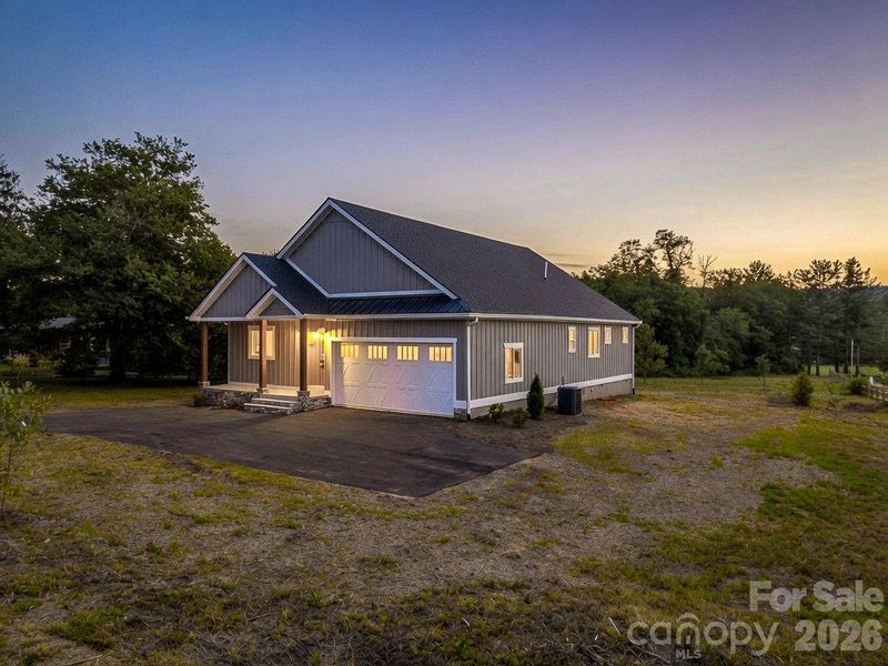 Front right twilight view, custom modern farmhouse, 2 car attached garage, covered front porch and hardyboard siding Front right twilight view, custom modern farmhouse, 2 car attached garage, covered front porch and hardyboard siding