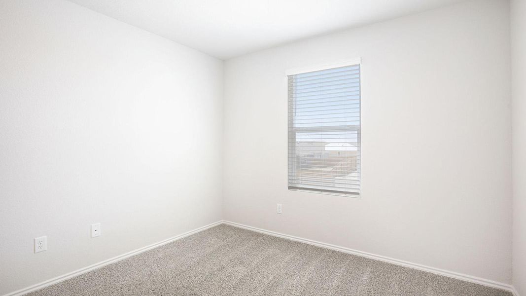 Bright room featuring light gray carpeting, white baseboards, and a window with horizontal blinds