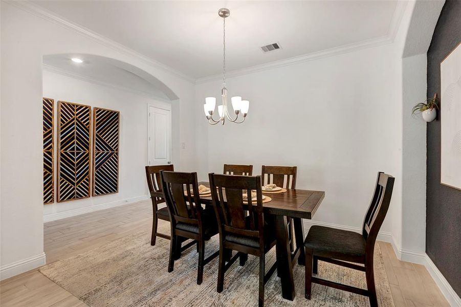 Spacious dining room with cute chandelier.