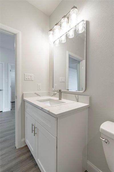 Bathroom featuring vanity, toilet, and hardwood / wood-style floors