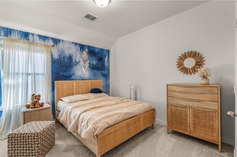 Bedroom with lofted ceiling and carpet floors