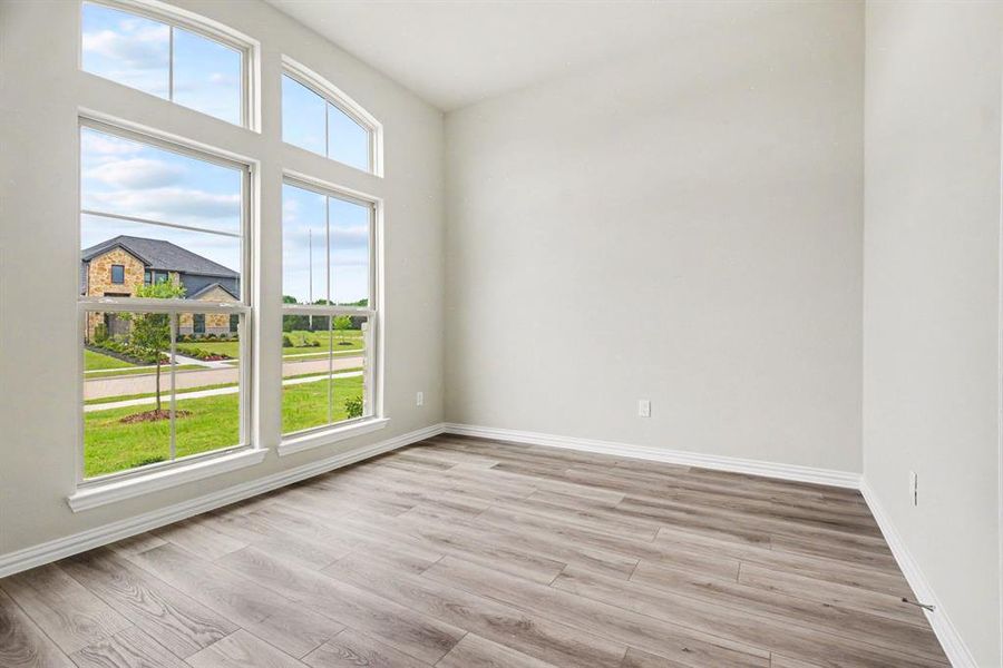 Room featuring a vaulted ceiling and extensive multi-pane windows with an arched transom Room featuring a vaulted ceiling and extensive multi-pane windows with an arched transom