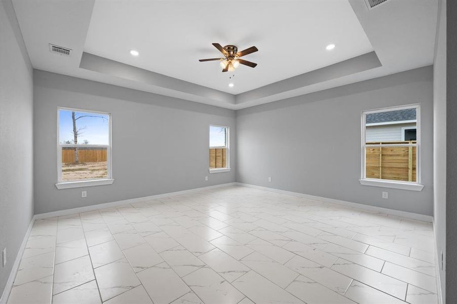 Oversized primary bedroom with high ceilings and plenty of natural light. No carpet!