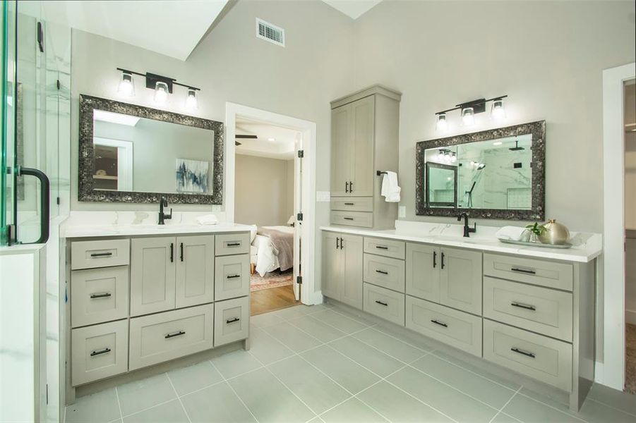 Bathroom with tile patterned flooring, an enclosed shower, and vanity