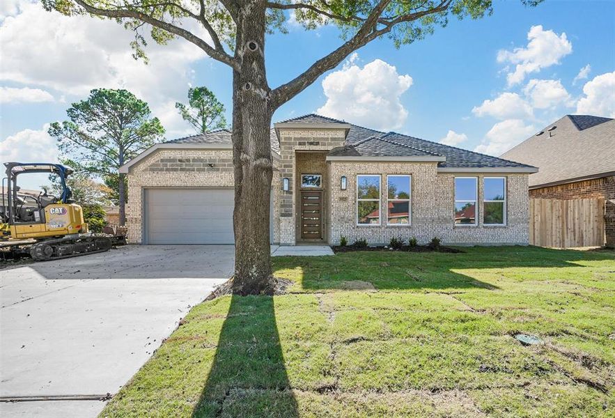 View of front facade with a front yard and a garage