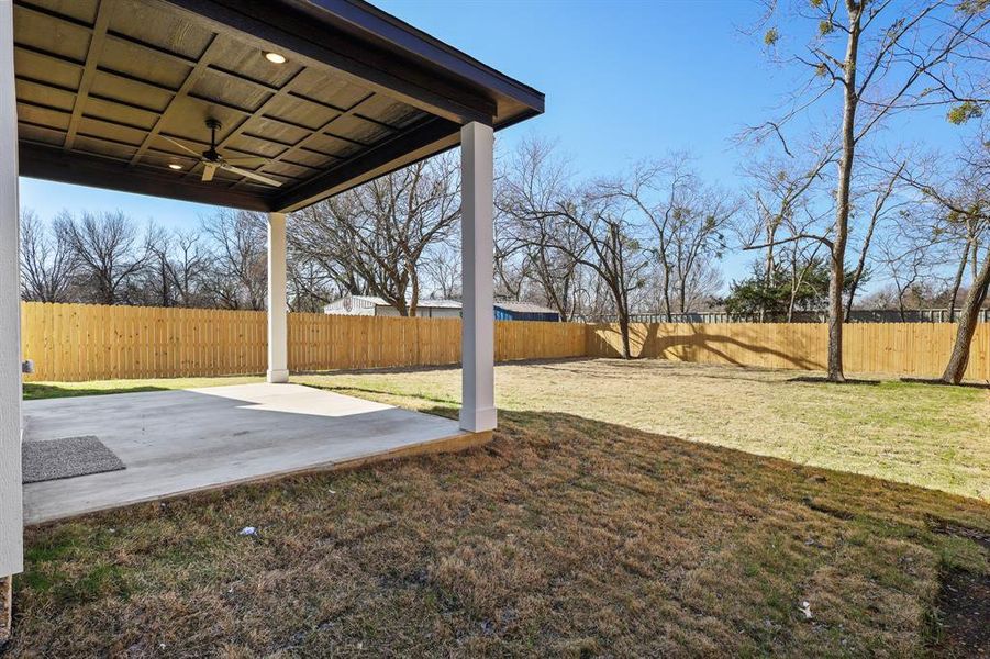 View of yard with ceiling fan and a patio