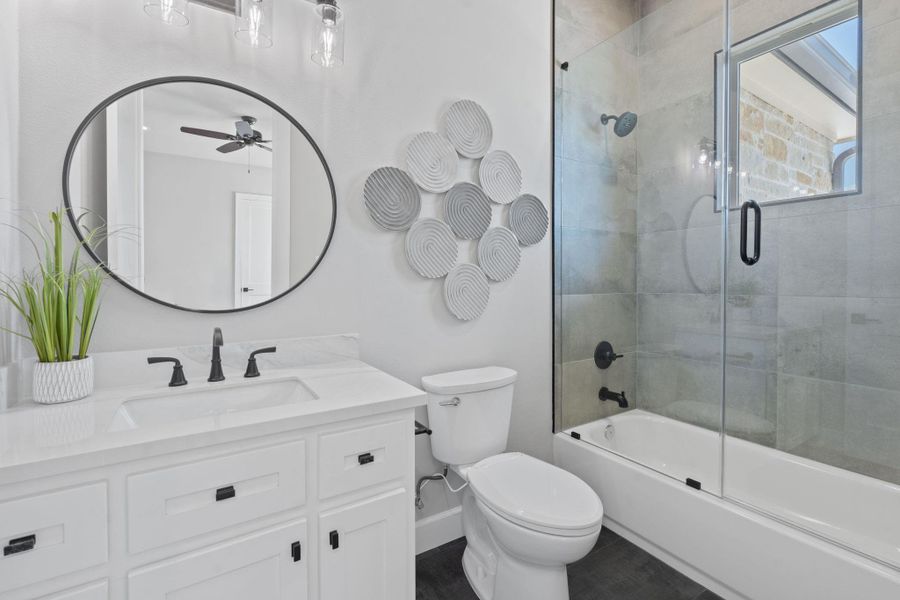 Full bath with vanity, ceiling fan, and shower / bath combination with glass door