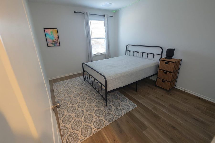 Bedroom with wood finished floors and baseboards Bedroom with wood finished floors and baseboards