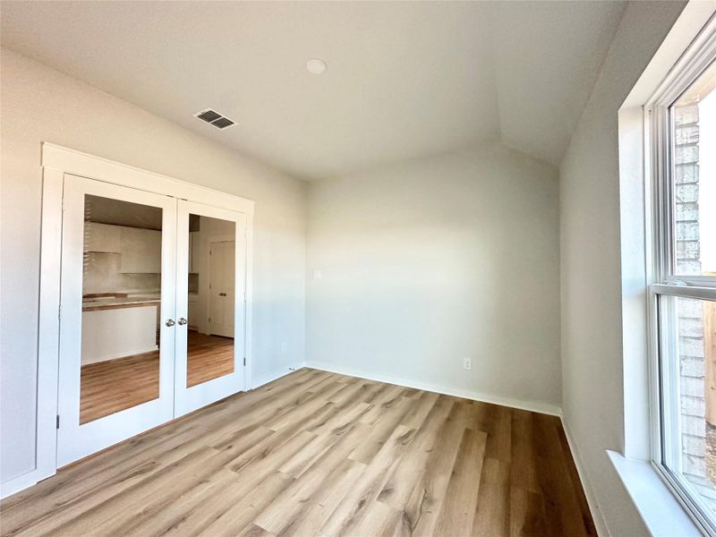 Unfurnished bedroom featuring french doors and light wood-style floors Unfurnished bedroom featuring french doors and light wood-style floors