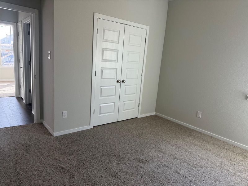 Plush carpeting and crisp white trim enhance this quiet room with double closet doors.