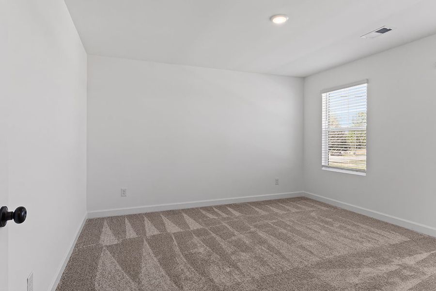 A room with a carpet and a window.