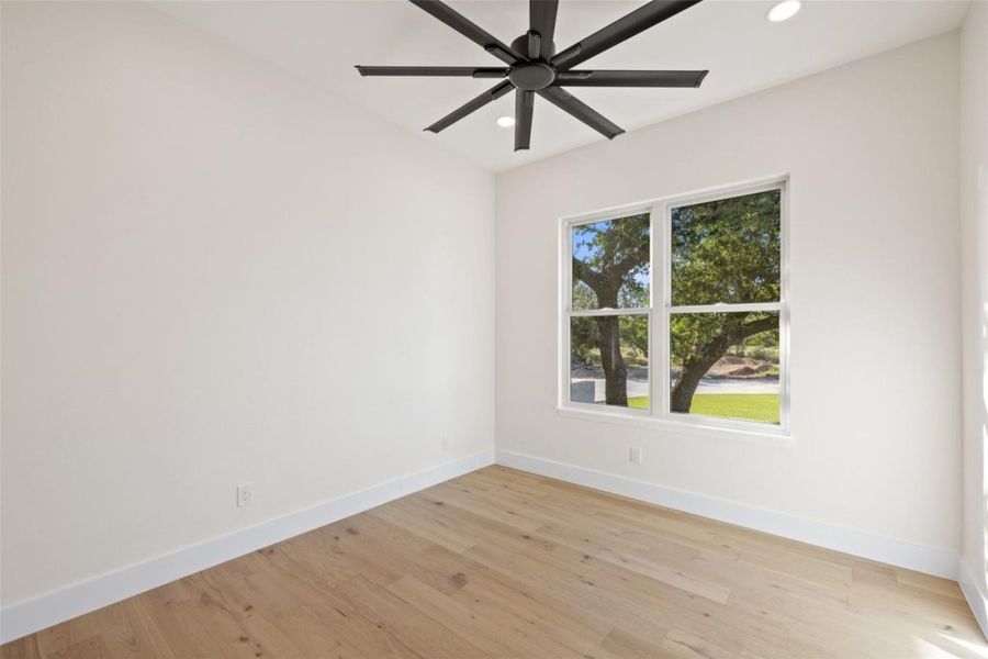 A well-lit room offers wood flooring, recessed lighting, and a modern ceiling fan. A well-lit room offers wood flooring, recessed lighting, and a modern ceiling fan.