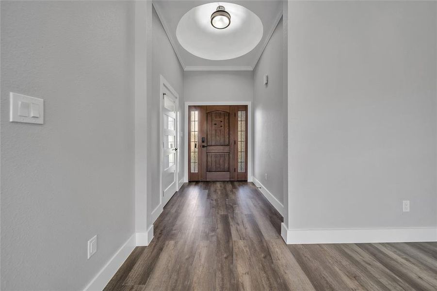 Foyer entrance with dark hardwood / wood-style floors and ornamental molding