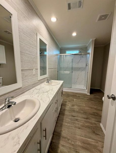 Dual vanity featuring integrated sinks, white cabinetry, and a marbled countertop