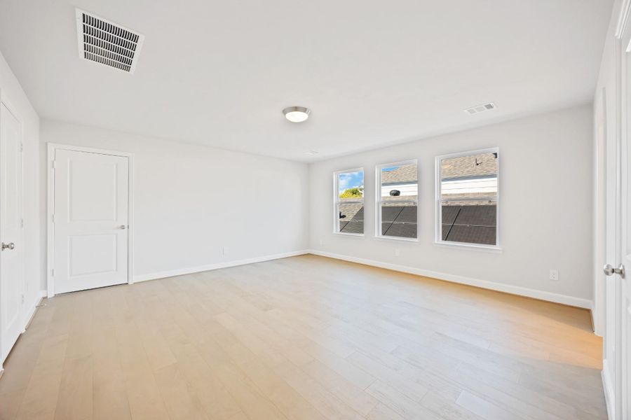 A remarkably large third-floor bedroom basks in brightness, featuring an ensuite bathroom and access to a substantial walk-in storage closet, ensuring privacy and comfort. A remarkably large third-floor bedroom basks in brightness, featuring an ensuite bathroom and access to a substantial walk-in storage closet, ensuring privacy and comfort.